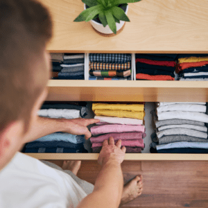 man selecting clothes out of organized drawer
