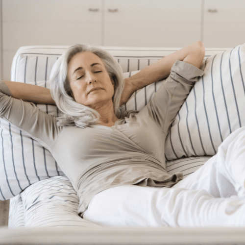 older woman relaxing on couch in a decluttered room