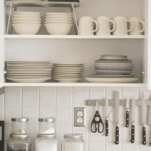 decluttered, organized kitchen cabinet filled with plates, cups, and bowls