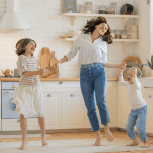 happy mom and kids dancing in organized kitchen